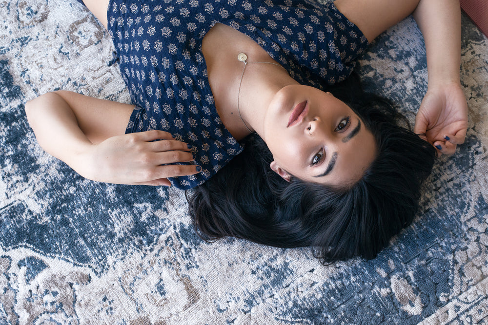 woman poses on blue patterned rug