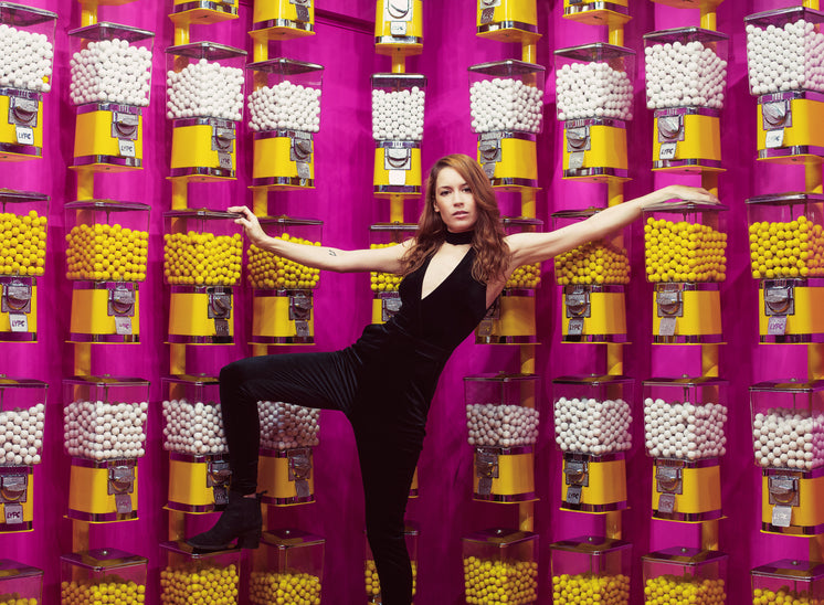 Woman Poses With A Wall Of Gumball Machines
