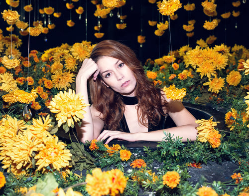 woman posing in center of yellow floral display