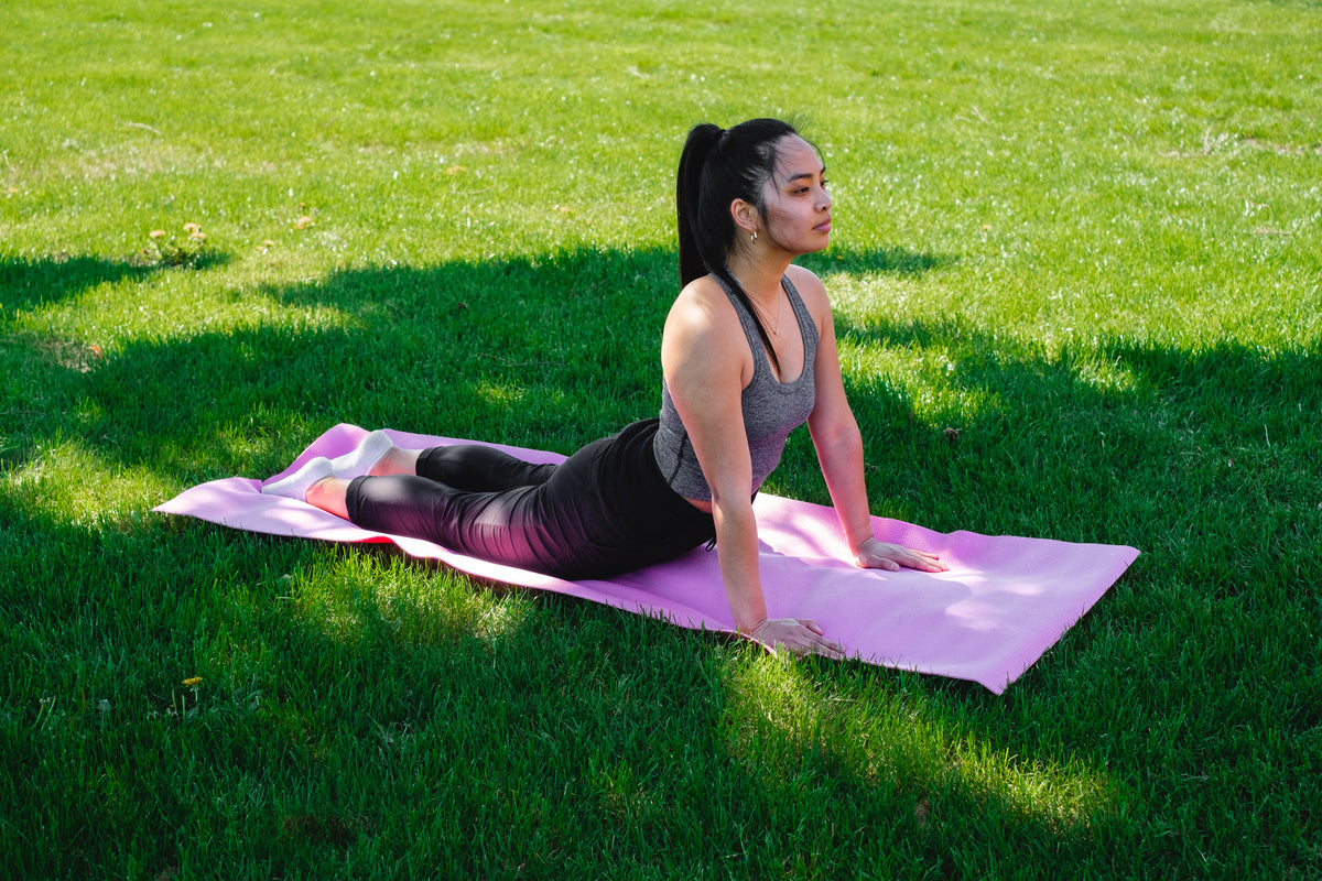 一名女子在绿草地上练习瑜伽