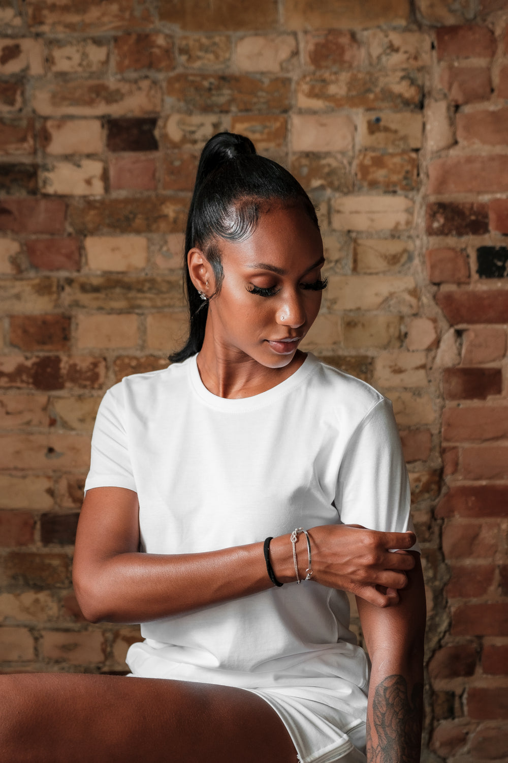 woman pulls on the sleeve of her blank white t shirt