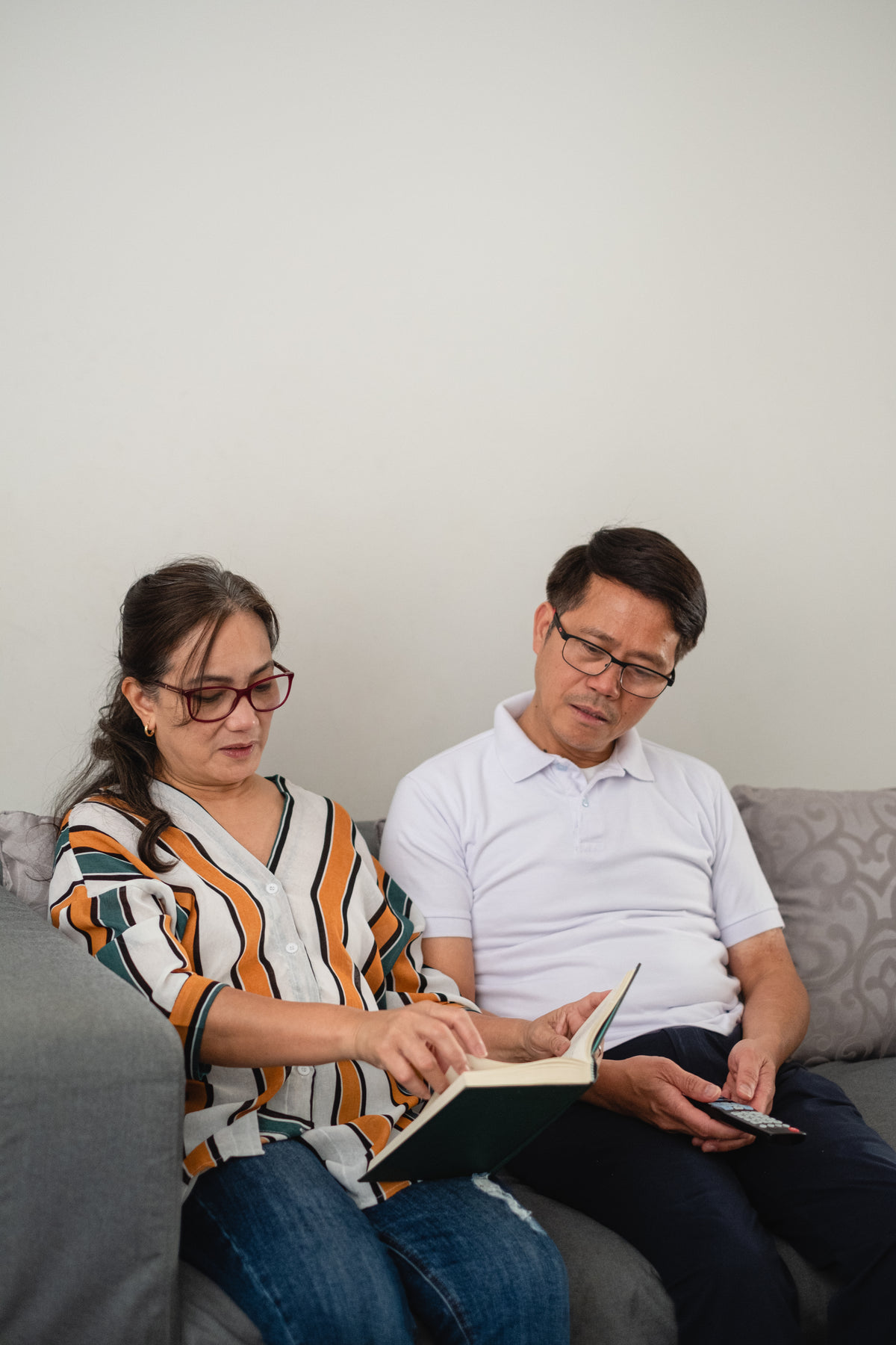 woman reading a book while man looks over