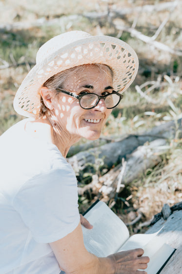 woman reading looks at the camera over her shoulder