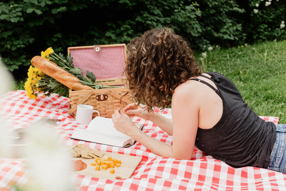 woman reading on picnic blanket