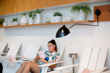 woman reads menu on white adirondack