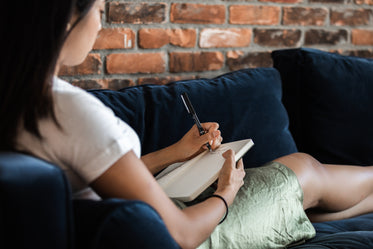 woman relazing and journalling on couch