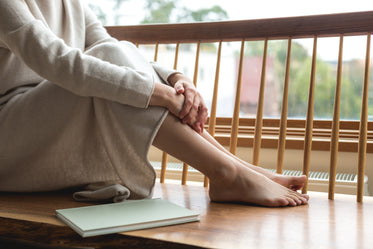 woman resting her feet by the window