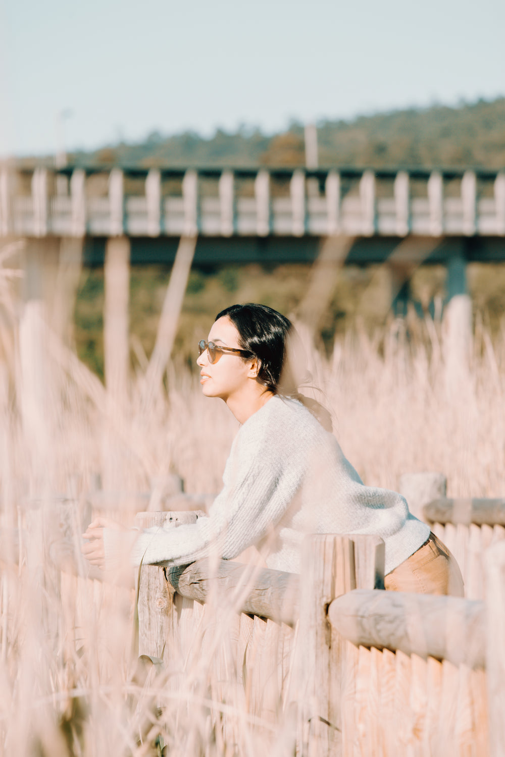 woman rests on a wooden fence outdoors