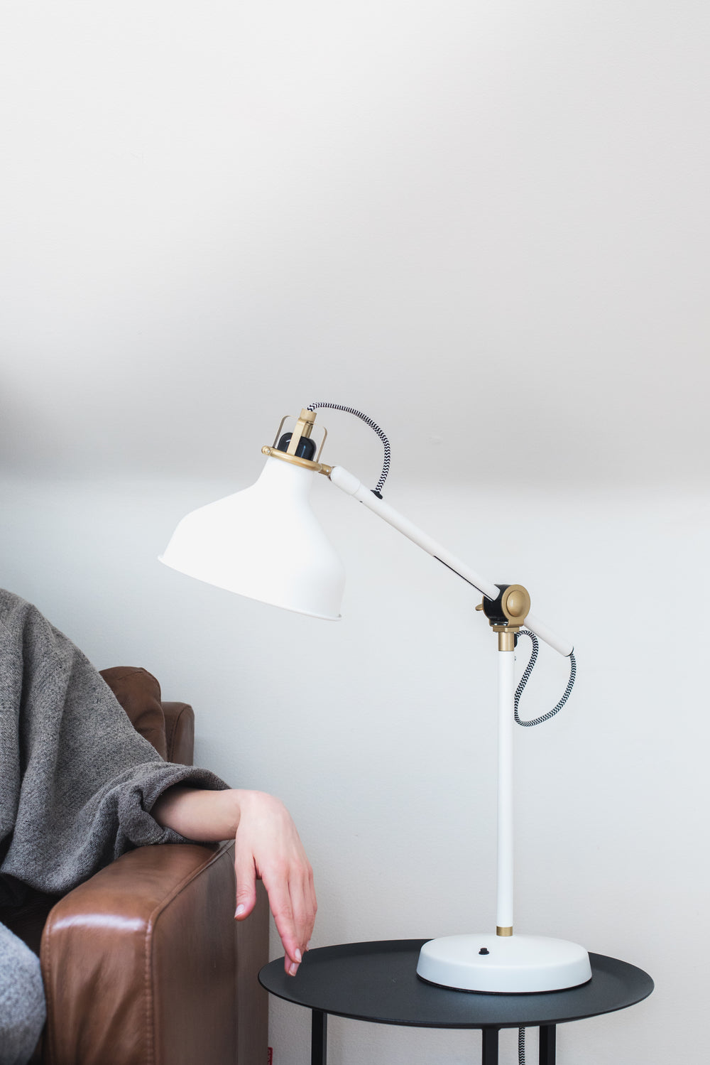 woman's hand on an armrest under a lamp