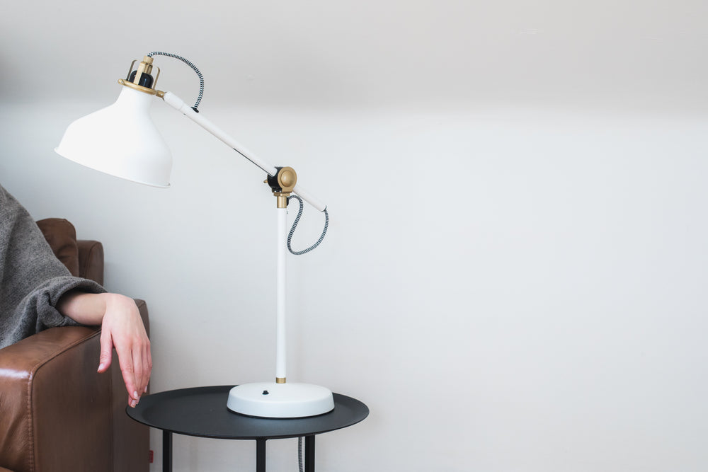 woman's hand on an armrest under a white lamp