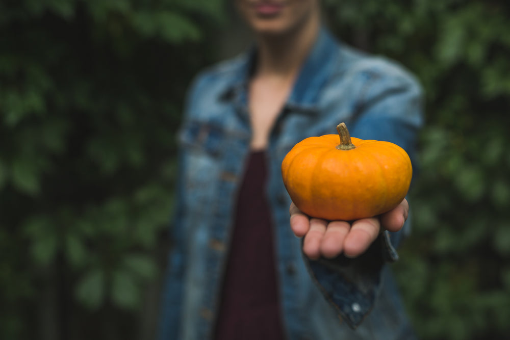 woman shows off small pumpkin