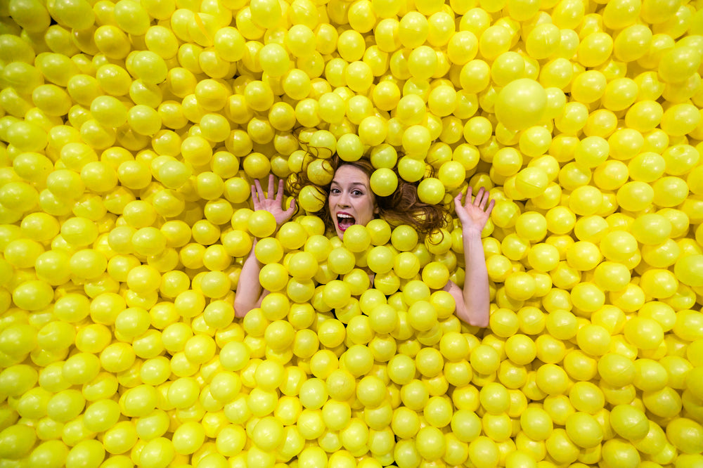 woman sinks into fun yellow balls