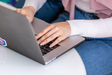 woman sits at table working on laptop