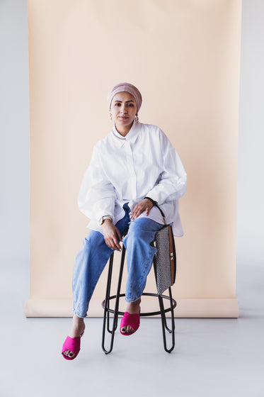 woman sits in front of backdrop