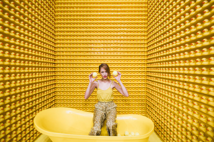 Woman Sits In Tub With Rubber Duckies