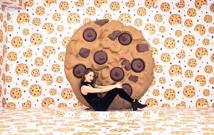 Woman Sits Next To A Giant Cookie In A Cookie-Themed Room