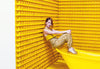 woman sits on a bath surrounded by rubber ducks