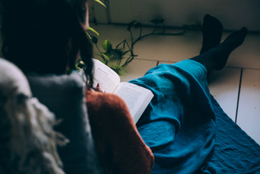 woman sits on floor reading