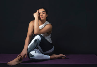 woman sits on purple mat