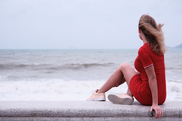 woman sits on seawall