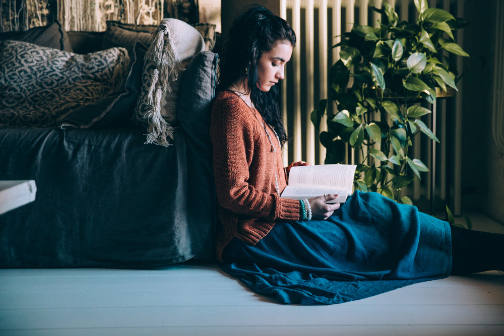 woman sits on the floor reading