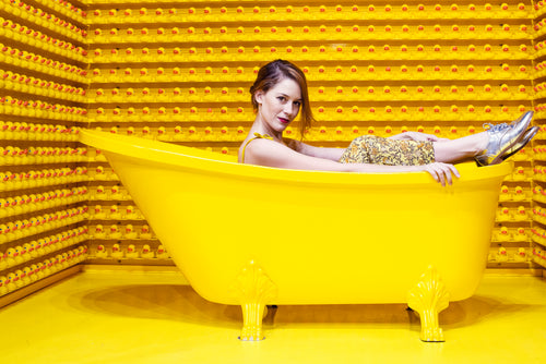 woman sits up in a yellow bath
