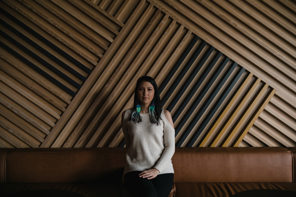 woman sitting against a large wooden wall