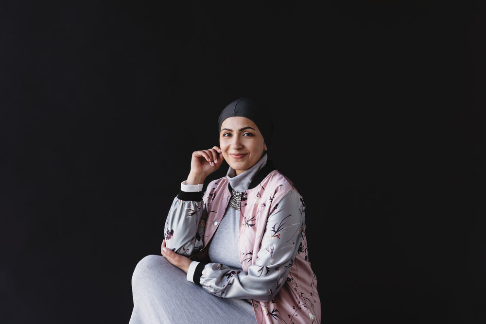 woman smiles against a black background