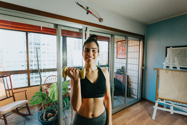 woman smiles and holds a yellow weight