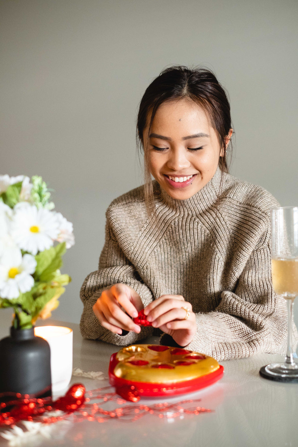 woman smiles as she opens a red chocolate heart