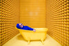 woman smiles in yellow bathtub