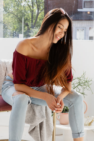 woman smiles sitting in sunny window