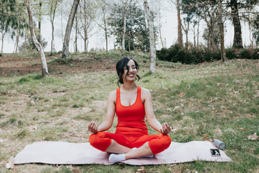 woman smiles while sitting in a yoga pose