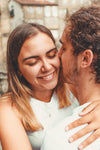 woman smiles wide with her face close to a man