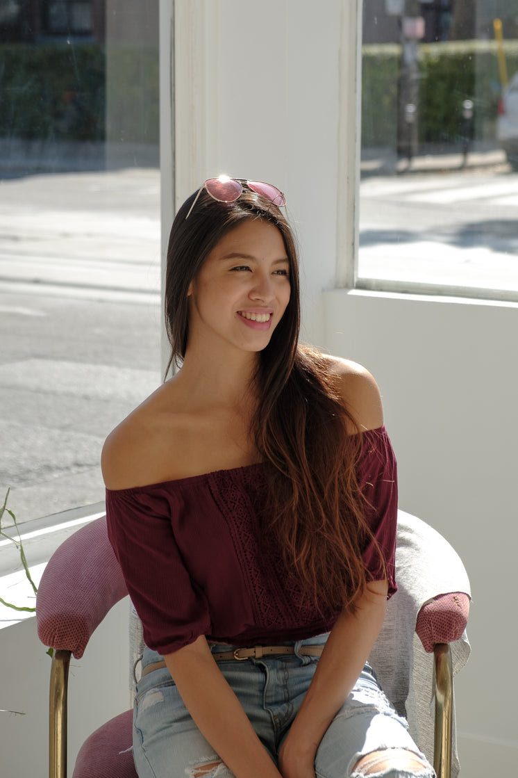 Woman Smiling While Sat In Sunny Window