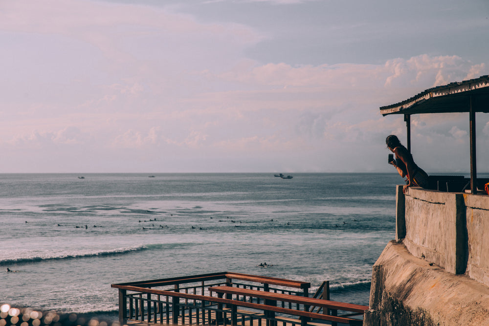 woman snapping a picture on her phone of beach