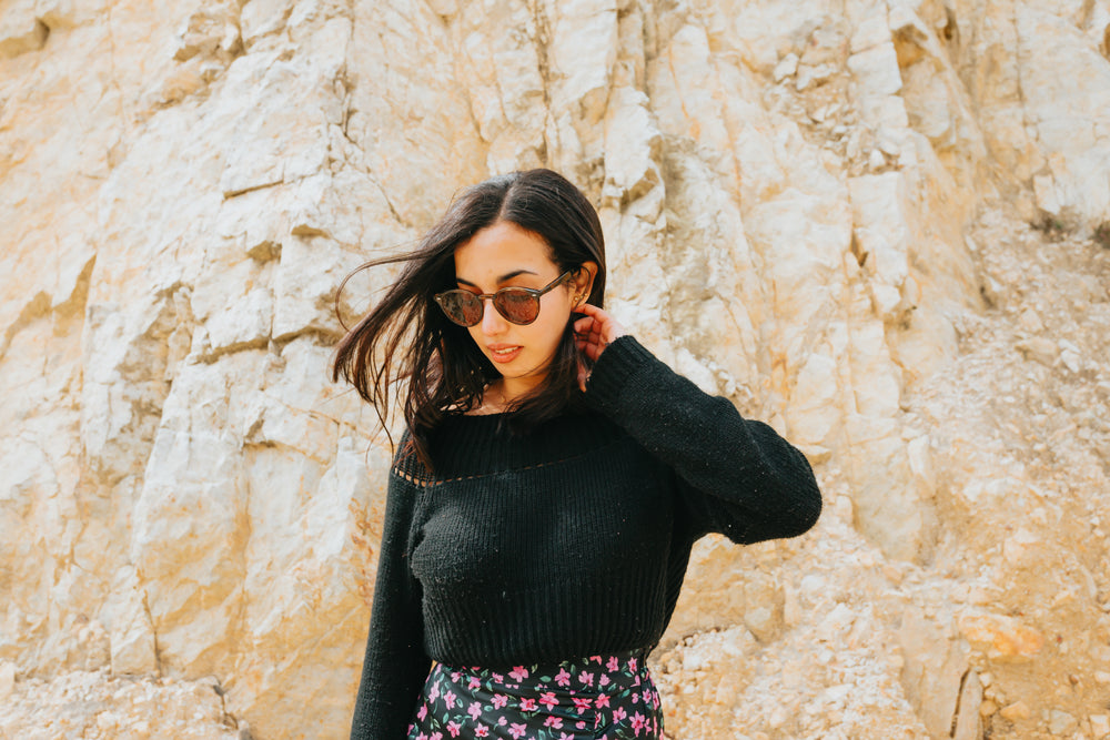 woman standing in from of a large rocky hill