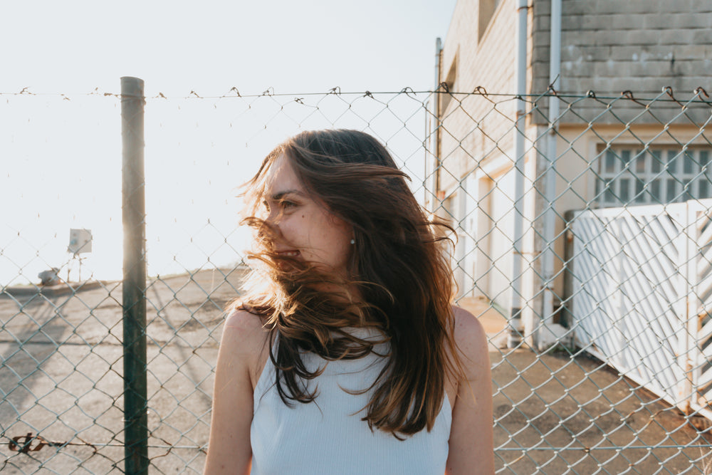 woman standing in front of a metal fence