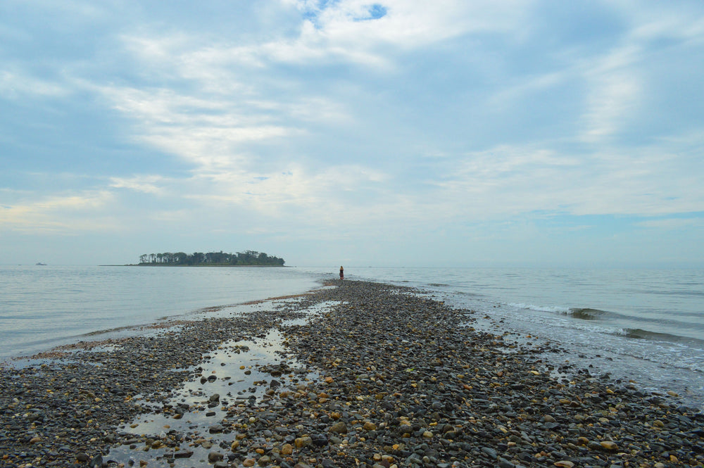 woman standing on rocky outcropping by the sea