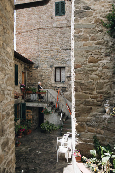 woman stands at the steps of her house