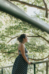 woman stands in a sundress in a forest