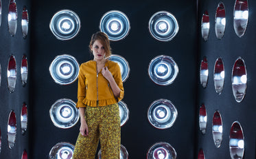 woman stands in small room with silver dome lights on walls