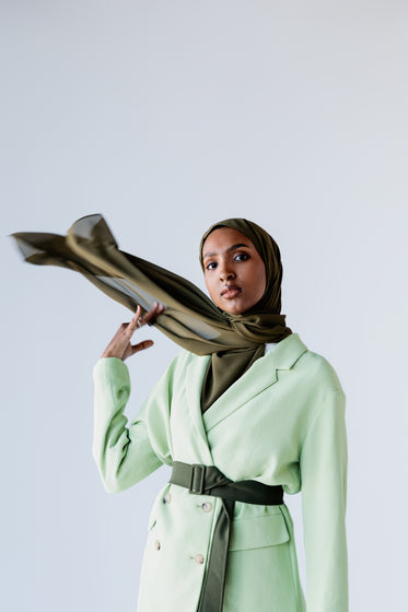 woman swings scarf around her shoulder