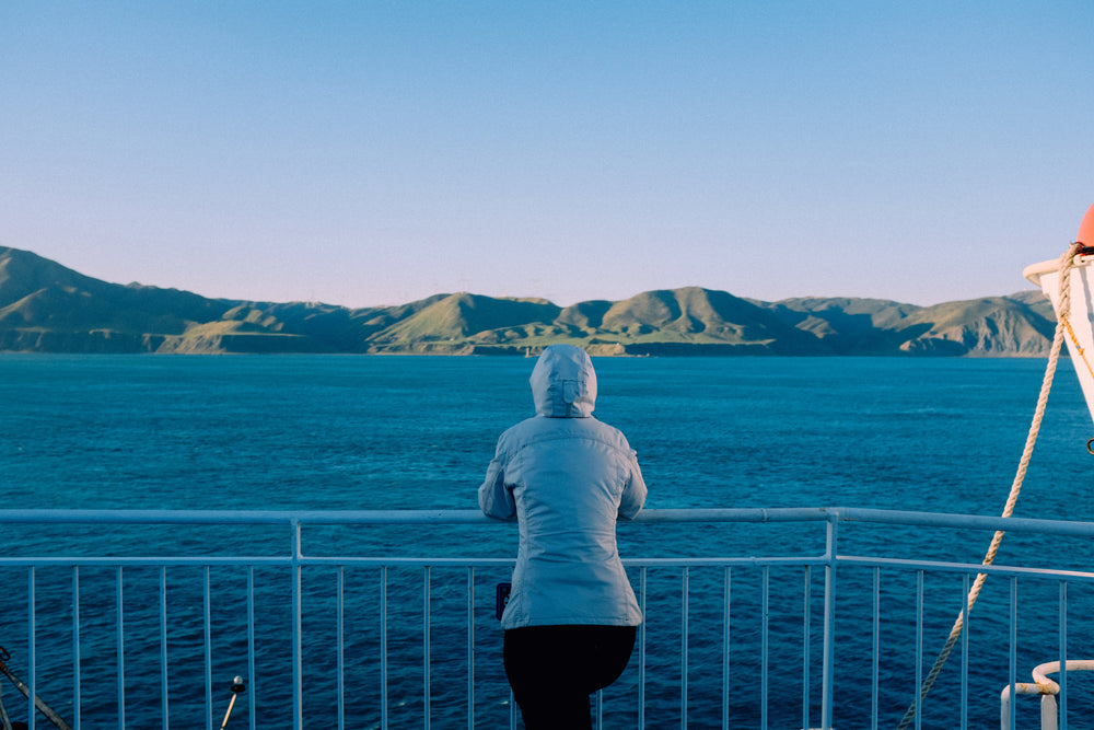 woman takes in the mountain view from ferry