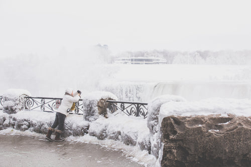 woman takes winter waterfall photo