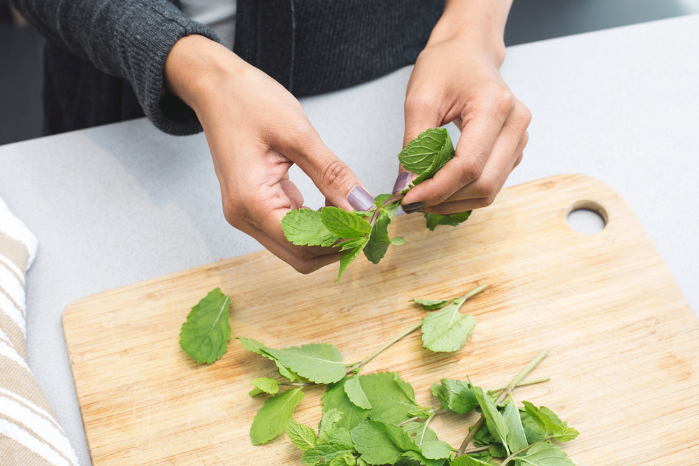 woman tearing mint leaves