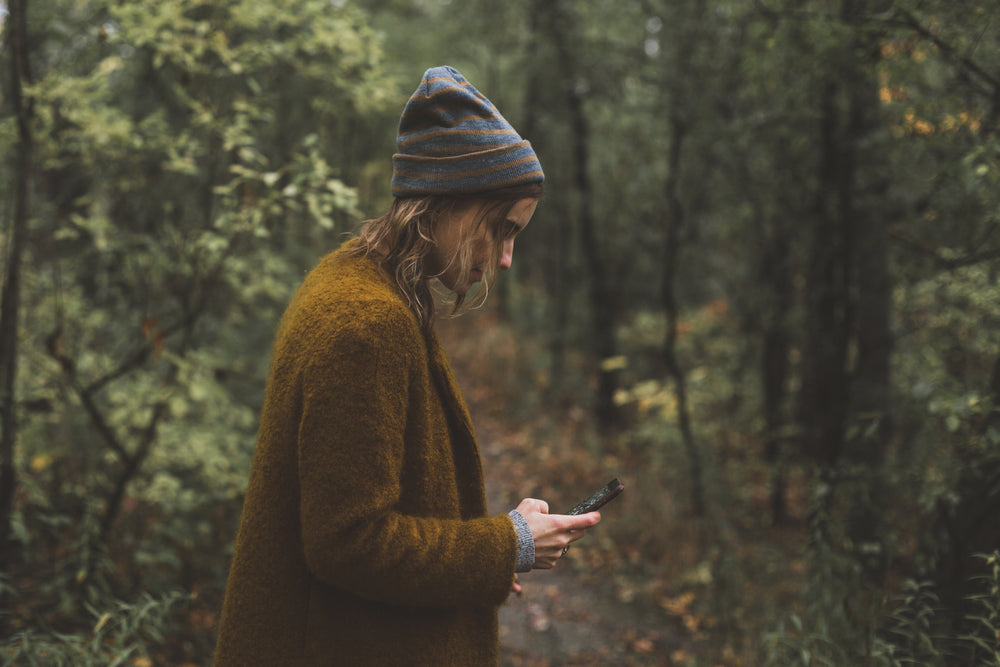 woman texts during autumn hike