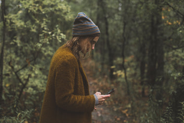 woman texts during autumn hike