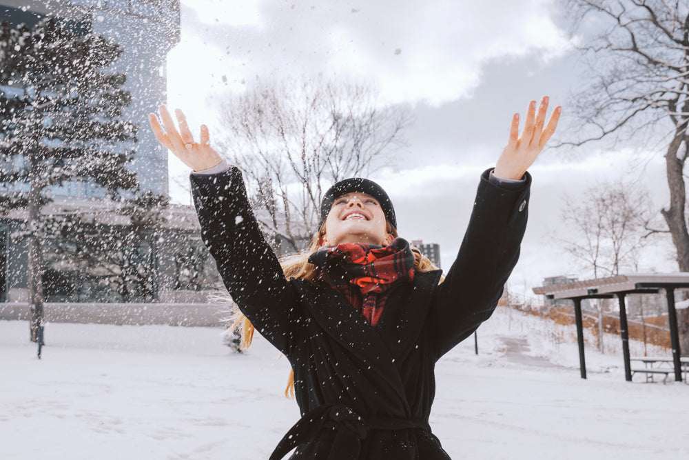 woman throwing snow in park