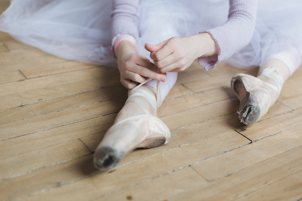 woman ties dance shoes